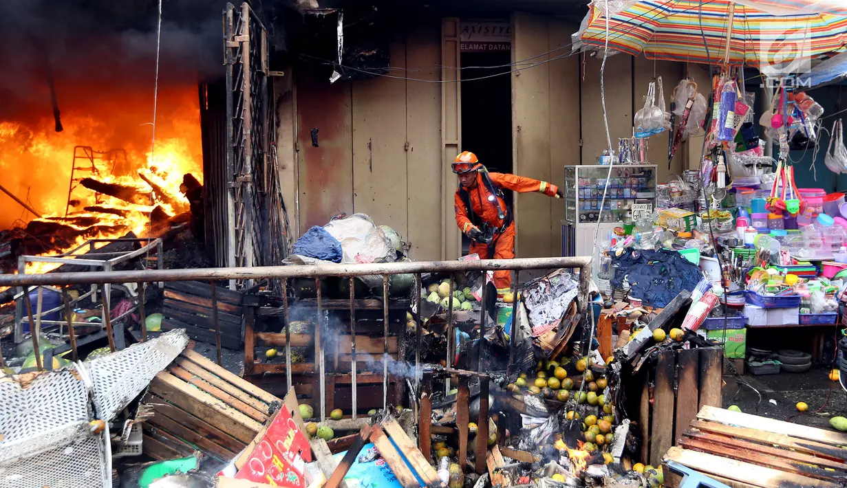 Petugas memindahkan barang-barang di sekitar lokasi kebakaran di Pasar Kebayoran Lama, Jakarta, Selasa (13/6). Tidak ada korban jiwa dalam kebakaran tersebut. (Liputan6.com/Johan Tallo)