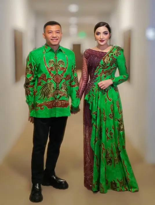 Bahkan sentuhan batik pada dressnya pun tak dibuat biasa-biasa saja. Ashanty menggabungkan nuansa dress berwarna wine dengan kain batik hijau yang serasi dengan yang dikenakan Anang. [Foto: Instagram/ashanty_ash]