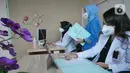 Dokter Spesialis Onkologi Radiasi, Ade Margaretha (kanan) bersama Dokter Umum Indria Febriani (kiri) saat memberikan pelayanan medis jarak jauh atau Telemedicine pada pasien umum di Rumah Sakit Umum Daerah (RSUD) Pasar Minggu, Jakarta, Jumat (18/2/2022). (Liputan6.com/Herman Zakharia)