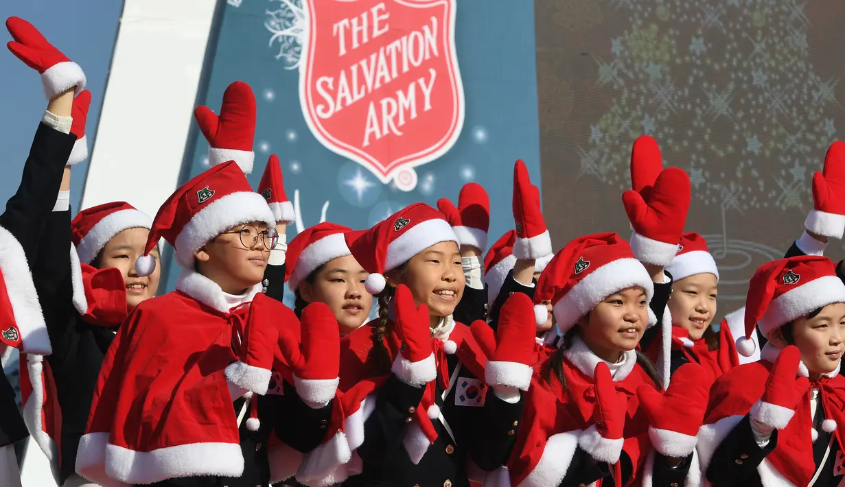 Anak-anak Korea Selatan mengenakan pakaian Santa Claus saat kampanye penggalangan dana untuk orang miskin di depan Istana Gyeongbokgung, Seoul, Jumat (30/11). (Jung Yeon-je/AFP)
