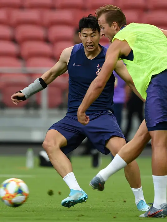 Penyerang Tottenham Hotspur,Son Heung-Min (kiri) berusaha merebut bola dari rekannya Harry Kane selama mengikuti latihan di Singapura  (19/7/2019). Tottenham akan bertanding melawan Juventus pada International Champions Cup 2019 di National Stadium, Singapura. (AFP Photo/Roslan Rahman)