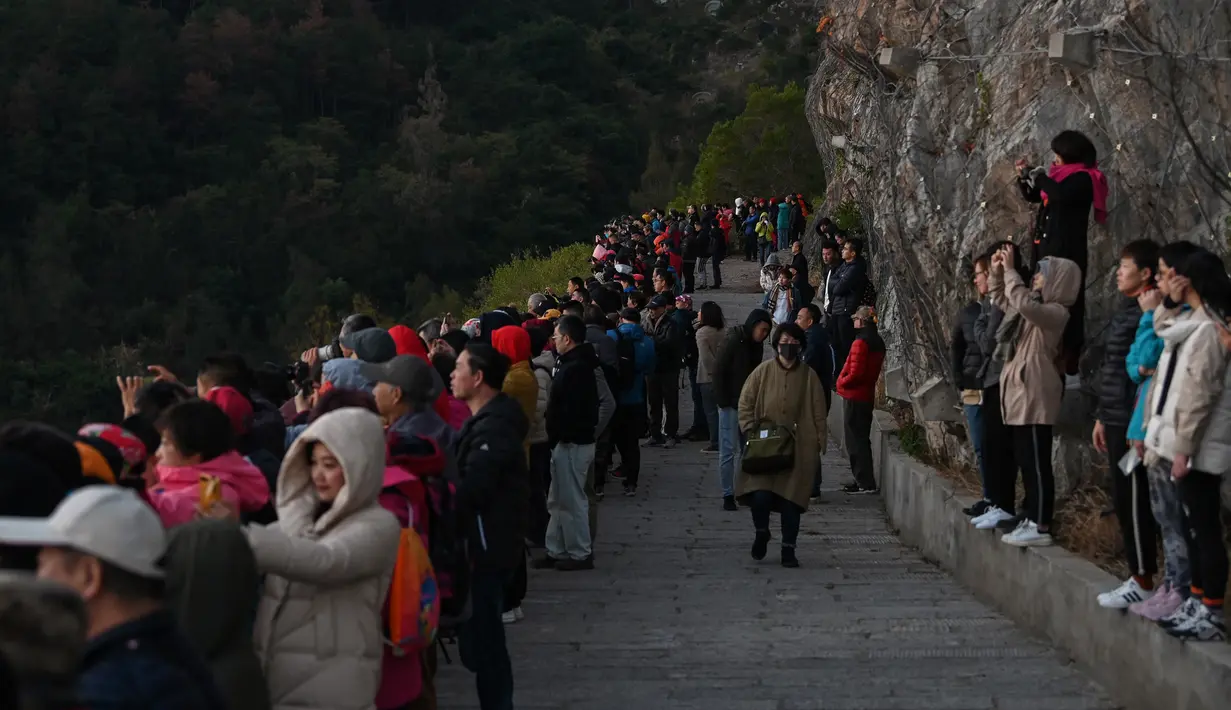 Wisatawan meyaksikan matahari terbit di Niu Yu, Xiapu, Provinsi Fujian, China, Jumat (13/12/2019). Xiapu menjadi daya tarik tersendiri bagi fotografer pemula karena jauh dari gedung pencakar langit dan hiruk pikuk kota-kota besar di China. (RETAMAL HECTOR/AFP)
