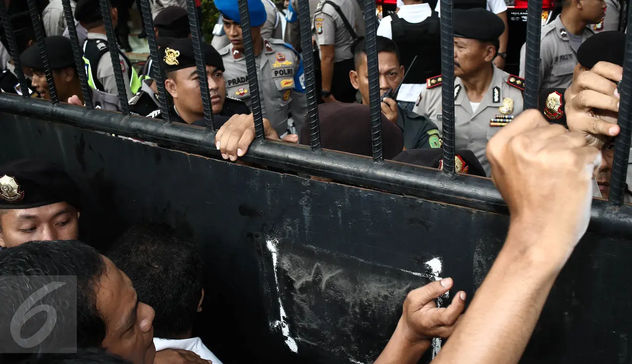 Petugas kepolisian berjaga di pintu masuk Pengadilan Negeri (PN) Jakarta Utara, Selasa (13/12). Ratusan orang membludak berebut masuk ke ruang sidang perdana Basuki Tjahaja Purnama (Ahok) yang berkapasitas maksimal 80 orang. (Liputan6.com/Faizal Fanani)