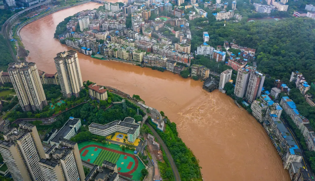 Foto dari udara kondisi banjir di Distrik Qijiang, Kota Chongqing, China barat daya (1/7/2020). Guyuran hujan telah menyebabkan peningkatan debit air ke sungai-sungai di daerah pusat kota, dan beberapa pagar pengaman di sepanjang sungai rusak oleh derasnya arus air. (Xinhua/Chen Xingyu)