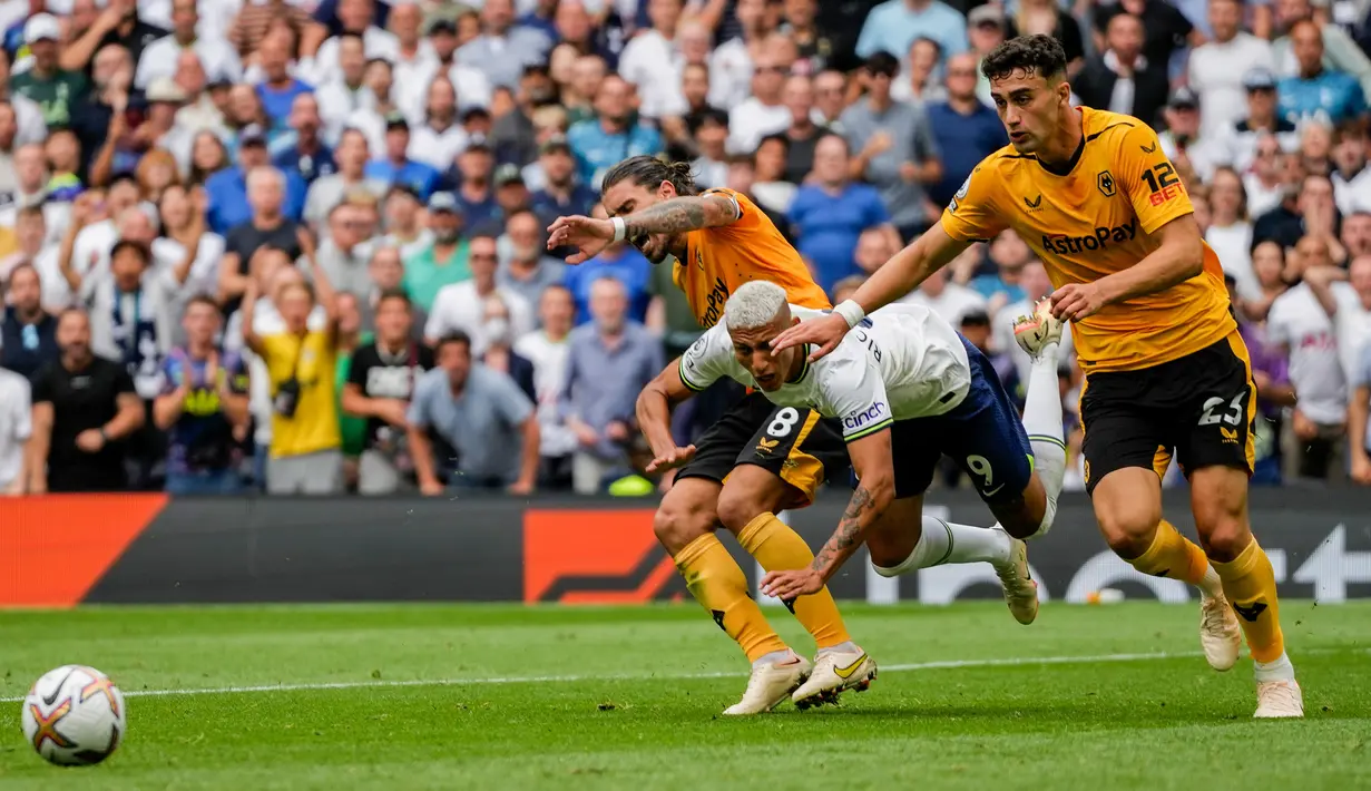 Pemain Tottenham Hotspur Richarlison (tengah) ditekel oleh pemain Wolverhampton Wanderers Ruben Neves dan Max Kilman (kanan) pada pertandingan sepak bola Liga Inggris di Tottenham Hotspur, London, Inggris, 20 Agustus 2022. Tottenham Hospur menang dengan skor 1-0 atas Wolverhampton Wanderers. (AP Photo/Frank Augstein)