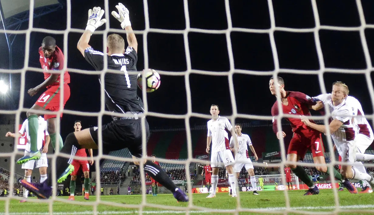 Aksi William Carvalho (kiri) menyundul bola ke gawang Latvia pada laga Kualifikasi Piala Dunia 2018 di Algarve stadium, Faro (13/11/2016). Portugal menang 4-1. (AFP/Patricia De Melo Moreira)