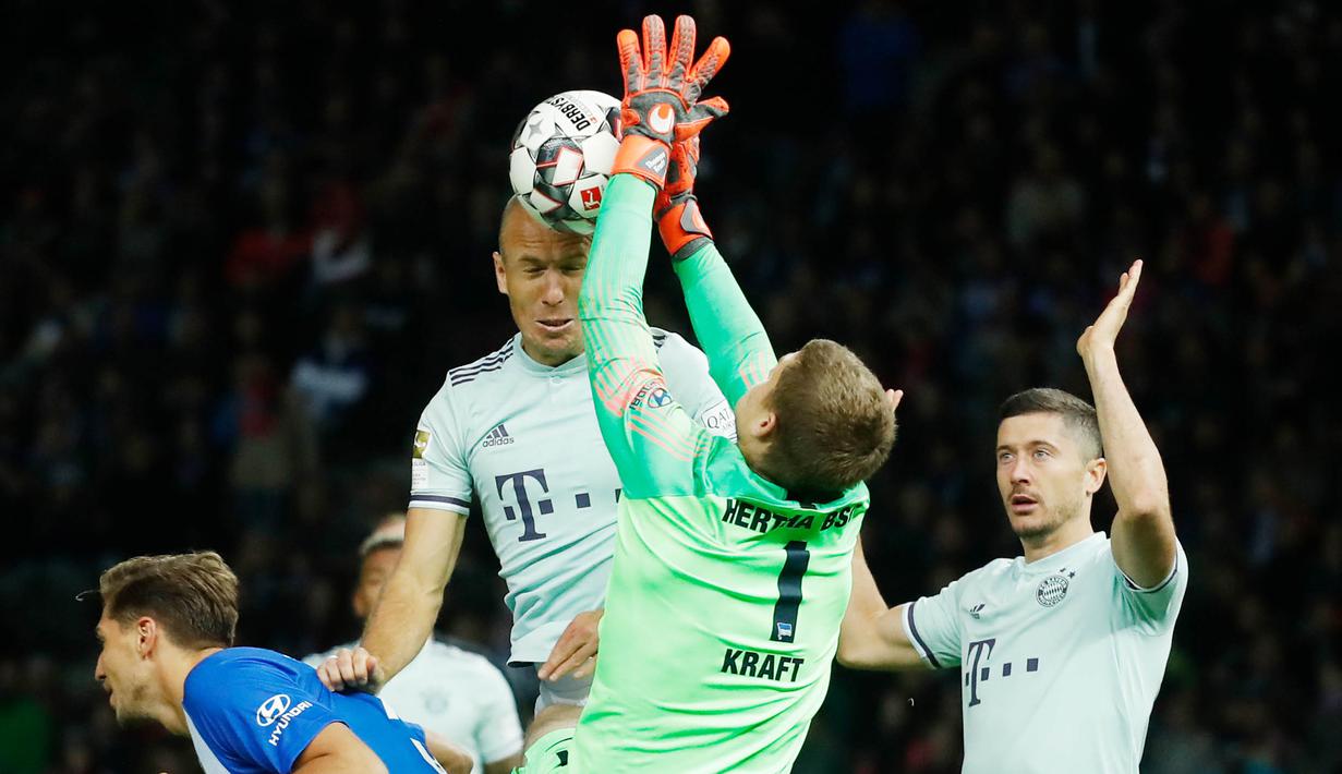 Kiper Hertha Berlin, Thomas Kraft, menghalau bola sundulan penyerang Bayern Munich, Arjen Robben, pada laga Bundesliga di Olympiastadion, Berlin, Sabtu (29/8/2018). Hertha Berlin menang 2-0 atas Bayern Munich. (AFP/Odd Andersen)