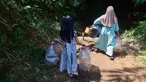 Seorang anak menemani ibunya Warga mengambir air dari satu-satunya sumber mata air di di Kampung Cijaura, Desa Cidokom, Bogor, Jawa Barat, Minggu (26/07/2026). (KLY/ Arie Basuki)
