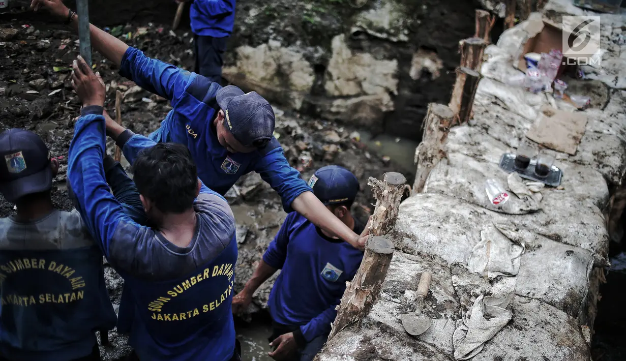 Petugas Suku Dinas SDA Jakarta Selatan membangun turap permanen di lokasi tanggul jebol di Kelurahan Jatipadang, Jakarta, Rabu (16/1). Sebuah tanggul di Kelurahan Jatipadang jebol karena meluapnya air Kali Pulo. (Liputan6.com/Faizal Fanani)