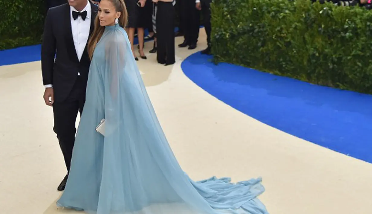 Hadir di Met Gala 2017, Jennifer Lopez tampil dengan gaun panjang yang menjuntai ke lantai berwarna biru langit. Sedangkan Alex Rodriguez, tampak elegan dengan setelan tuxedo berwarna hitamnya. (AFP/Bintang.com)
