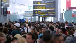 Ribuan penumpang menunggu untuk melewati kontrol keamanan di bandara Barcelona di Prat Llobregat, Spanyol  (4/8). Aksi tersebut sebagai bentuk protes terhadap bonus mereka yang belum dibayarkan pihak perusahaan. (AP Photo/Manu Fernandez)