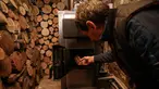 Tudor Popescu memasukkan kayu bakar ke tungku di ruang penyimpanan yang terpasang di rumahnya di Chisinau, Moldova, 15 Oktober 2022. Krisis energi yang melanda Eropa karena dipicu pemotongan aliran gas alam oleh Rusia di tengah perangnya melawan Ukraina telah memaksa beberapa orang untuk beralih ke kayu bakar untuk menghangatkan diri dalam cuaca yang beranjak dingin. (AP Photo/Aurel Obreja)