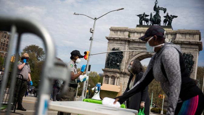 Petugas jagawana taman kota New York City membagikan masker gratis di Prospect Park di wilayah Brooklyn di New York, AS (3/5/2020). New York City (NYC) akan membagikan lebih dari 100.000 penutup wajah secara gratis di taman-taman di seluruh kota itu mulai 2 hingga 5 Mei. (Xinhua/Michael Nagle)