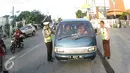 Petugas Kepolisian memberhentikan pengendara mobil di Simpang Maya, Tegal, Jawa Tengah Minggu (10/7). Pemberhentian dilakukan untuk mengecek muatan mobil agar aman saat berlalu lintas. (Liputan6.com/Herman Zakharia)