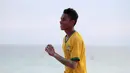 Seorang pemuda menggunakan jersey Brasil saat bermain bola dekat pantai di Desa Matwaer, Kei Kecil, Maluku (25/12/2017). Bermain bola di pasir menjadi daya tarik tersendiri bagi anak-anak dan pemuda desa. (Bola.com/Nick Hanoatubun)