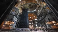 Turis mengunjungi bagian dalam Hagia Sophia di Istanbul, Turki pada 10 Juli 2020. Bangunan ini ini memiliki gaya arsitektur dari gabungan kontras dua agama, yakni arsitektur Kristen dan arsitektur Islam. (Ozan KOSE/AFP)