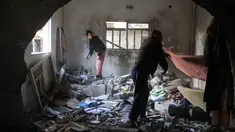 Warga Palestina menyelamatkan barang-barang dari sebuah rumah setelah serangan militer Israel terhadap rumah keluarga al-Houli, di mana empat orang dilaporkan tewas, di sebelah barat Deir al-Balah, di Jalur Gaza tengah, pada Jumat 16 Januari 2026. Jumlah korban tewas akibat serangan Israel di Jalur Gaza terus bertambah. (BASHAR TALEB/AFP)