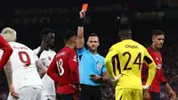 Wasit Ivan Kruzliak (tengah), memberikan kartu merah kepada pemain MU, Casemiro (tiga kiri), setelah melanggar pemain Galatasaray dalam pertandingan lanjutan Grup A Liga Champions 2023/2024 yang berlangsung di Old Trafford, Manchester, Rabu (4/10/2023) dini hari WIB. (AFP/Darren Staples)