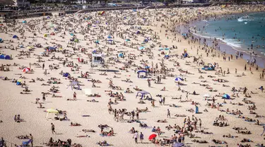 Orang-orang mengunjungi pantai Bondi di Sydney, Australia pada 5 Oktober 2020. Pengunjung ramai berjemur dan bermain di pantai dan berenang di laut saat pandemi Covid-19 masih berlangsung.  (Photo by DAVID GRAY / AFP)