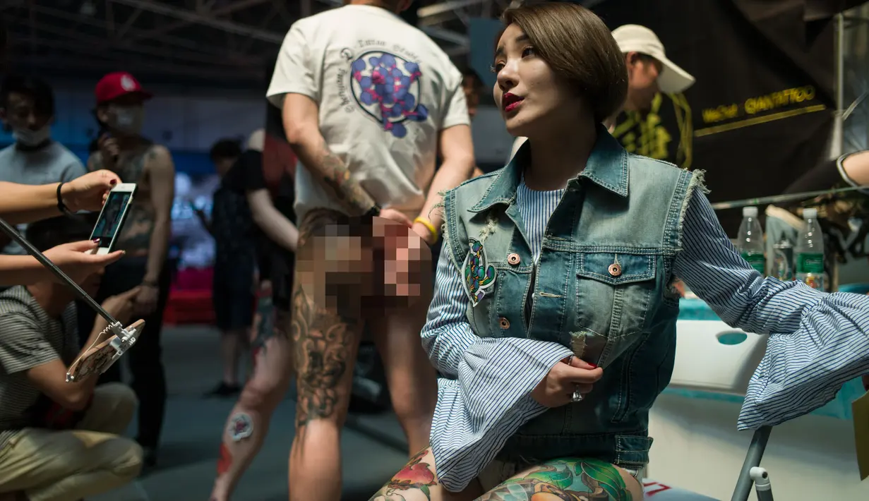 Seorang wanita berpose memperlihatkan tato dikakinya saat acara Langfang Internasional Tattoo di Hebei, China (29/5/2016). (AFP PHOTO / FRED Dufour)