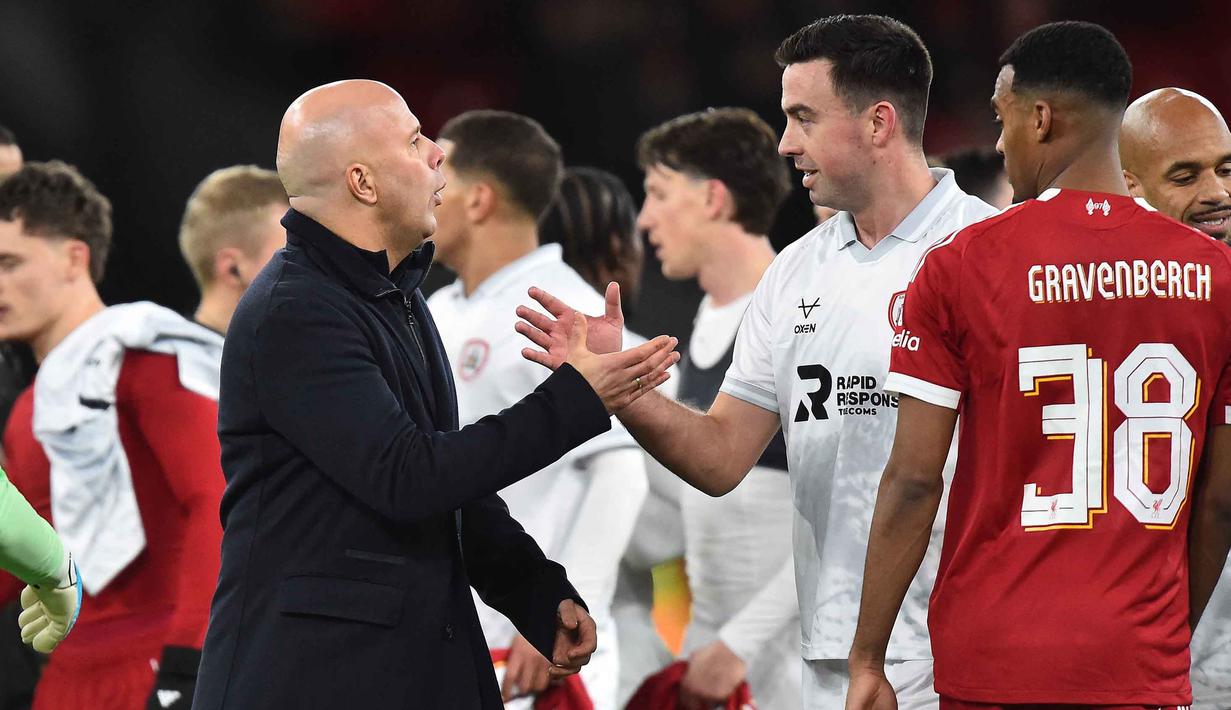 Pelatih Liverpool asal Belanda, Arne Slot berjabat tangan dengan bek Barnsley asal Irlandia, Eoghan O'Connell usai pertandingan putaran ketiga Piala FA Inggris di Stadion Anfield, pada Senin 12 Januari 2026 waktu setempat atau Selasa (13/1/2026) dini hari WIB. The Reds, tim besutan Arne Slot, sukses menyudahi perlawanan sengit Barnsley dengan skor akhir 4-1. (PETER POWELL/AFP)