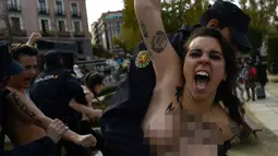 Aktivis Femen ditangkap polisi saat melakukan aksi telanjang dada memprotes penggalian makam diktator Spanyol Francisco Franco selama pertemuan tahunan di Madrid, Spanyol (24/11/2019). Aksi ini sekaligus memperingati kematian ke-44 Francisco Franco. (AFP/Oscar Del Pozo)