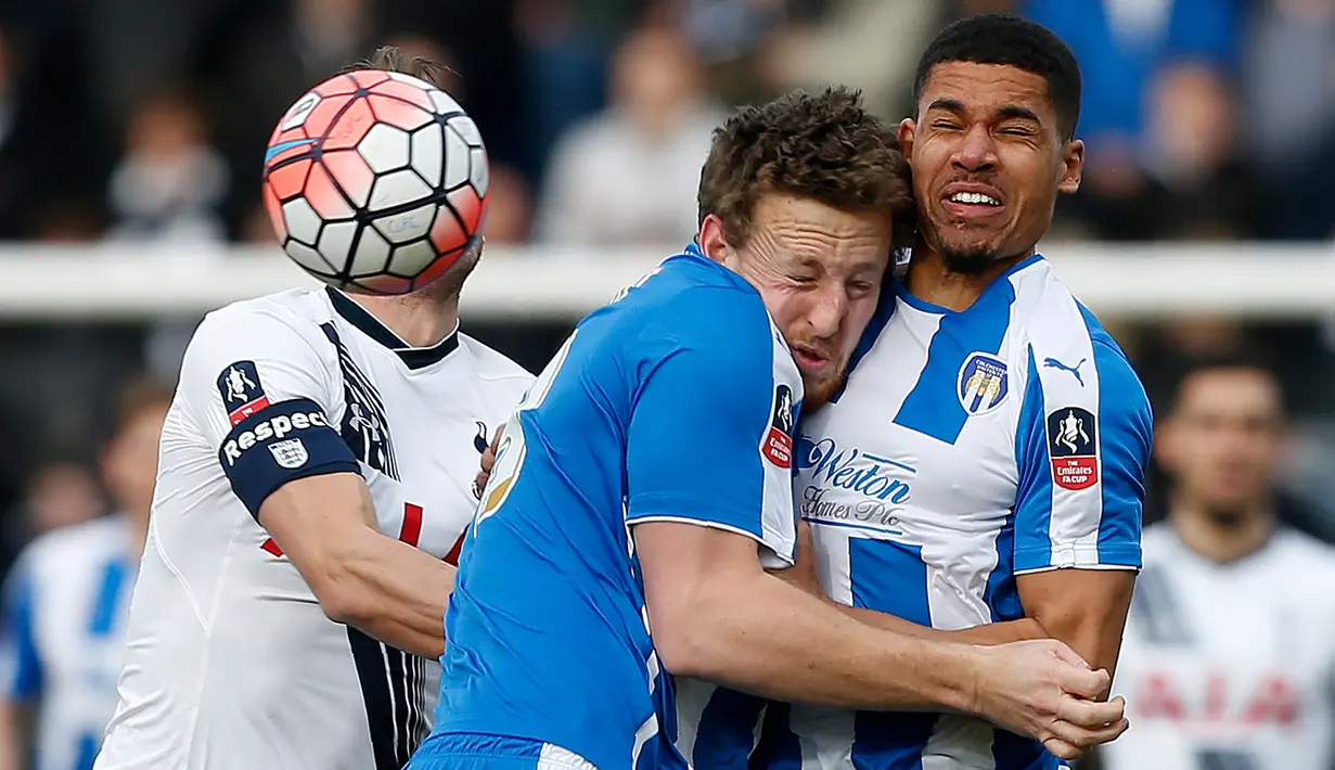 Pemain Colchester United, Tom Eastman (tengah) bertabrakan dengan rekannya Alex Wynter saat berebut bola dalam putaran keempat Piala FA di Stadion Weston Homes Community, Colchester, Inggris. (30/1/2016). (AFP/Ian Kington)