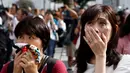 Ekspresi dua warga saat menyaksikan video pidato Kaisar Akihito di Tokyo, Jepang, (8/8). Kaisar yang bertahta sejak 25 tahun lalu mengungkapkan kekhawatiran tidak mampu melaksanakan tugas-tugas Kekaisaran secara penuh. (REUTERS/Kim Kyung-Hoon)