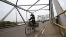 Pengendara sepeda melintasi jembatan Bangkir Indramayu, Jawa Barat, Jumat (30 /6). H+5 Indramayu Kota ke Arah Jakarta melalui Jalur Utara diprediksi mulai di padati arus balik pada Malam dan esok hari H+6. (Liputan6.com/Helmi Afandi)