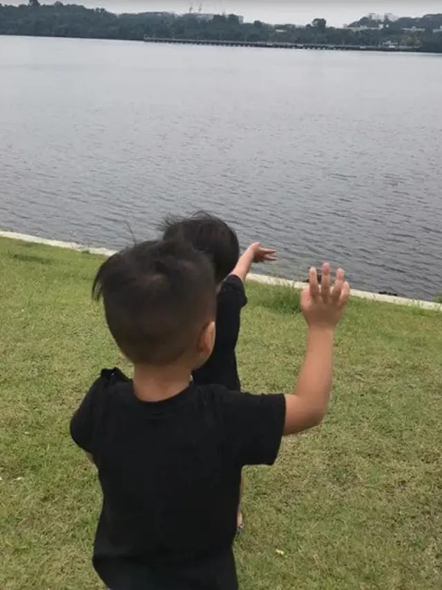 Terpisah karena Lockdown, Bapak dan Anak Saling Melambaikan Tangan dari Seberang Sungai