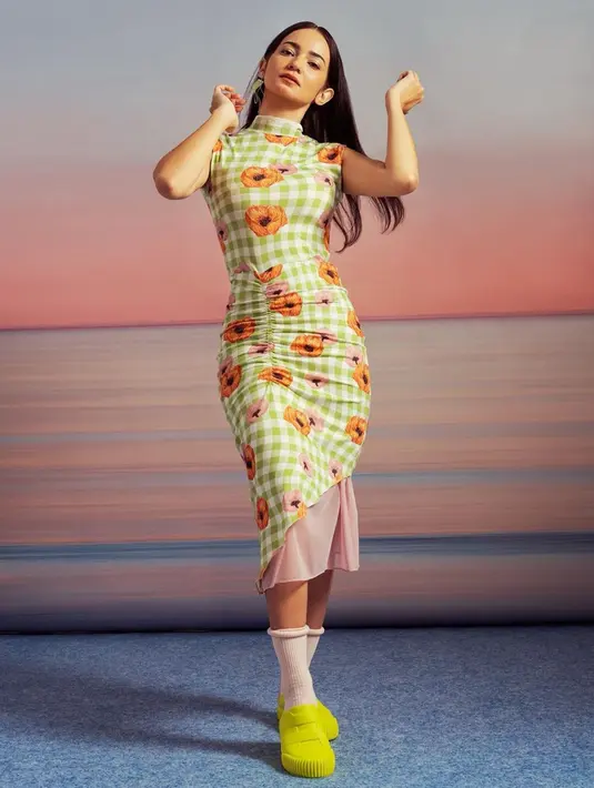 Dalam pemotretan kali ini, Enzy Storia tampil menawan dengan gaun slim fit motif kotak dan bunga. Sepatu kuning yang dipakainya pun membuat konsep pemotretannya terasa berwarna. (Liputan6.com/IG/@enzystoria)