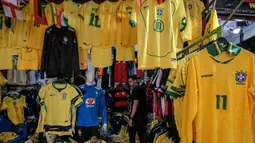 Seorang pria melihat kaus tim sepak bola nasional Brasil yang dipajang di pasar Saara, Rio de Janeiro, Brasil, pada Selasa 9 Juni 2026, menjelang turnamen Piala Dunia FIFA 2026. (Nelson ALMEIDA/AFP)
