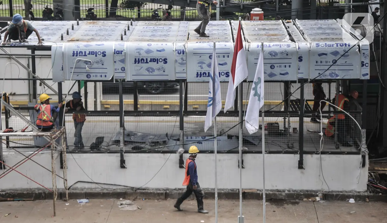 Aktivitas pekerja saat menyelesaikan proyek revitalisasi Halte Transjakarta Gelora Bung Karno (GBK), Jakarta Pusat, Senin (25/7/2022). PT TransJakarta terus mengebut proyek konstruksi revitalisasi sembilan halte yang akan berlangsung sekitar enam bulan dan akan difungsikan kembali secara bertahap sampai dengan dirampungkan secara keseluruhan pada Desember 2022. (merdeka.com/Iqbal S Nugroho)