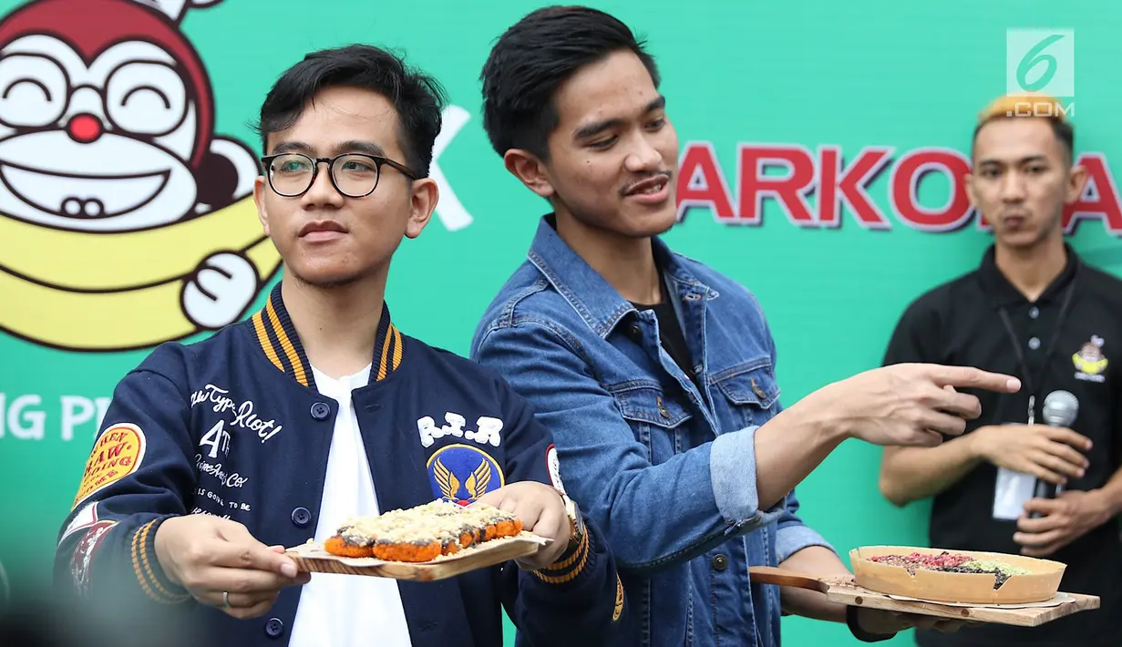 Putra Presiden Joko Widodo atau Jokowi, Gibran Rakabuming dan Kaesang Pangarep menunjukkan Sang Pisang dan Markobar saat launching outlet baru di Cikini, Jakarta, Minggu (11/3). Outlet tersebut hasil kolaborasi keduanya. (Liputan6.com/Immanuel Antonius)