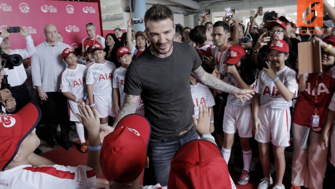 Legenda sepak bola Inggris, David Beckham, menyapa fans cilik di Stadion Soemantri Brodjonegoro, Jakarta, Minggu (25/3/2018). AIA membagikan 10.000 bola kepada akademi sepak bola di Indonesia. (Bola.com/M Iqbal Ichsan)