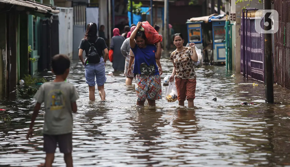 Warga melintasi banjir di salah satu permukiman penduduk di Kawasan Cengkareng Barat, Jakarta Barat, Kamis (30/1/2025). (Liputan6.com/Angga Yuniar)