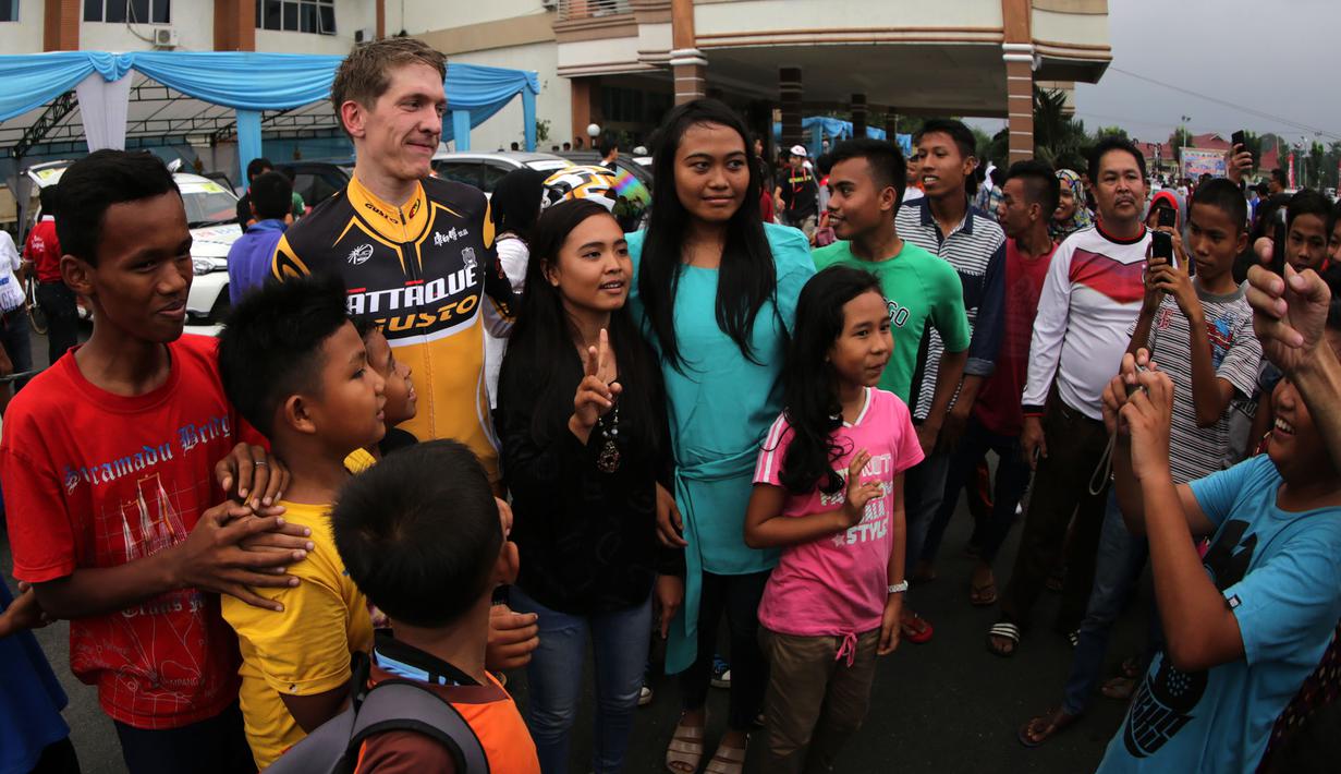 Pebalap Attaque Team Gusto Taiwan, Thomas Rabou, menjadi incaran foto bersama setelah menjuarai Etape 7 Tour de Singkarak 2015 antara Pasaman-Pasaman Barat, Jumat (9/10/2015). (Bola.com/Arief Bagus)