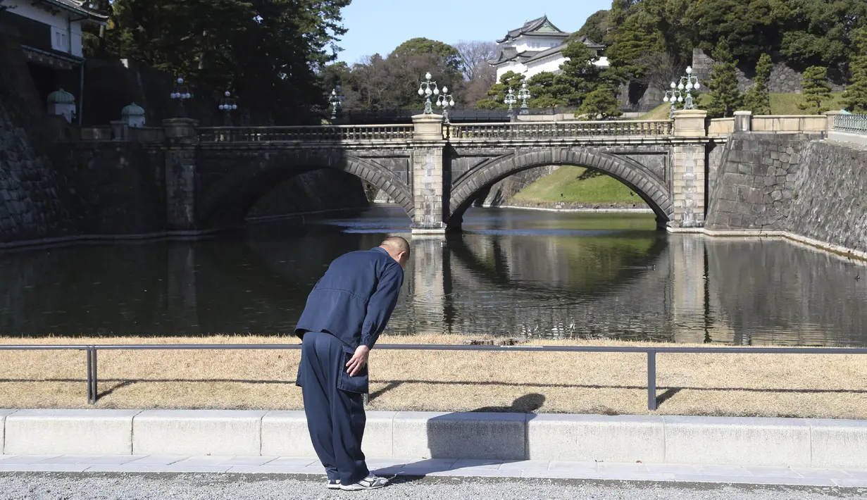 Seorang pria memberi hormat untuk merayakan ulang tahun Kaisar Naruhito ke-60 Jepang, di Tokyo, Minggu, (23/2/2020). Tahun ini merupakan ulang tahun pertamanya yang digelar sebagai seorang kaisar, sejak Naruhito naik Tahta Krisantemum pada Mei 2019. (AP Photo/Koji Sasahara)