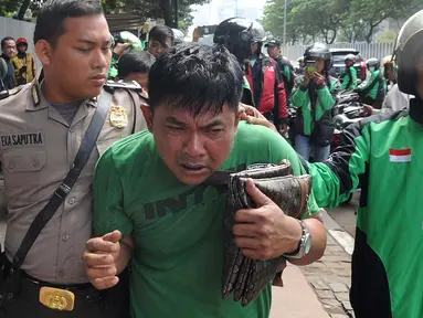 Petugas kepolisian mengamankan terduga copet menuju Mapolda Metro Jaya di Jalan Jenderal Sudirman, Jakarta (2/4). Pelaku tertangkap tangan oleh korbannya saat mencopet handphone di jembatan penyeberangan orang (JPO). (Merdeka.com/Arie Basuki)