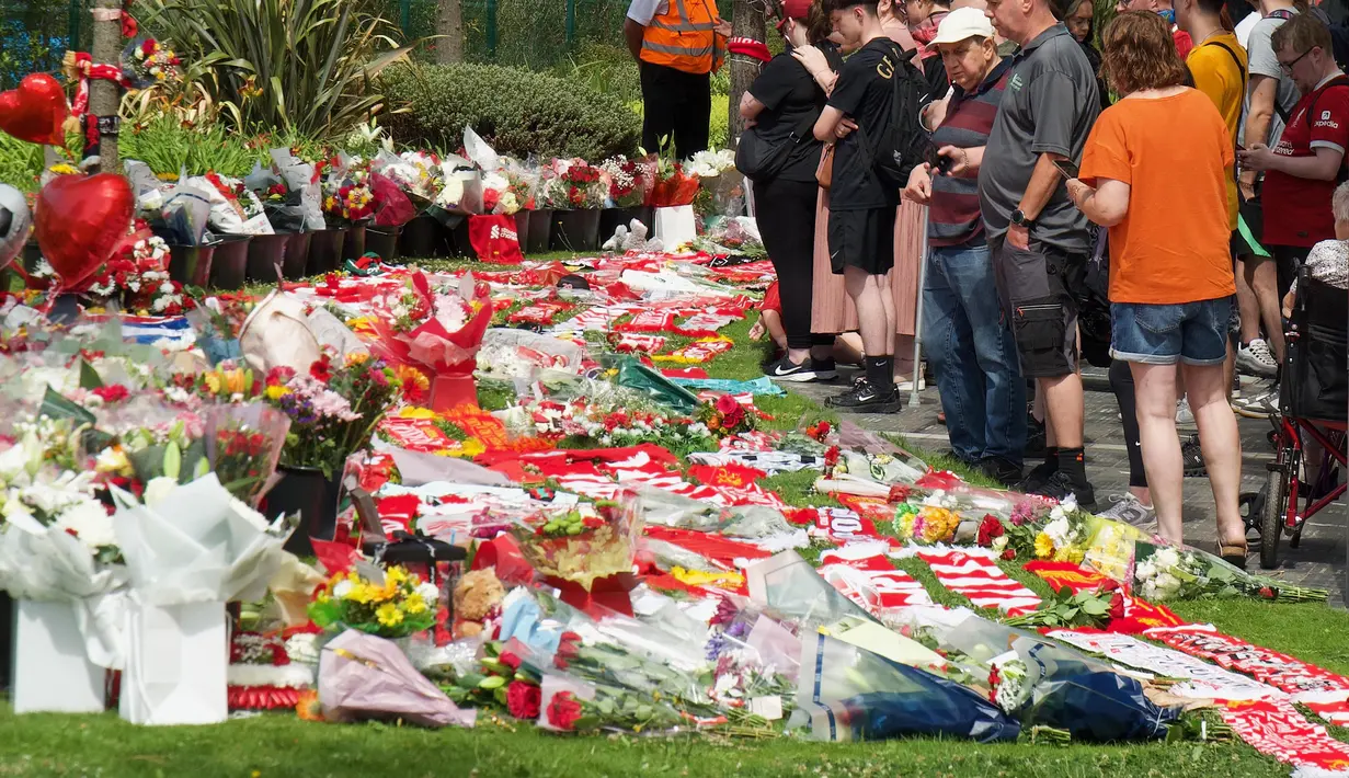 Para simpatisan meninggalkan bunga di tugu peringatan yang didirikan di dekat lapangan sepak bola Anfield untuk penyerang asal Portugal, Diogo Jota, di Liverpool, Inggris, 3 Juli 2025. (Paul BARKER/AFP)