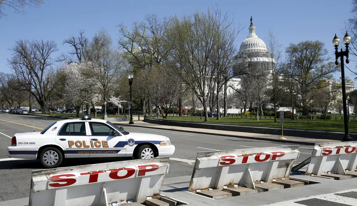 Polisi memblokir area sekitar Gedung Capitol, Washington DC, Amerika Serikat, pasca serentetan penembakan yang terjadi di lokasi tersebut, Senin (28/3). Sempat terjadi tembak-menembak dengan petugas sebelum pelaku dilumpuhkan. (REUTERS/Yuri Gripas)