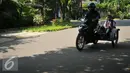 Orang tua mengunakana sepeda motor mengantar anaknya di hari pertama sekolah di SD Gunung 01, Jakarta, Senin (18/7). Usai libur panjang para siswa kembali bersekolah untuk tahun ajaran 2016-2017.(Liputan6.com/Gempur M Surya)