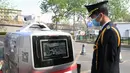 Petugas memeriksa mobil pengiriman tanpa awak di Institut Teknologi Beijing, Beijing, China, Senin (6/4/2020). Institut Teknologi Beijing menggunakan mobil pengiriman tanpa awak berteknologi 5G yang dapat mengukur suhu tubuh orang-orang yang memasuki kampus. (Xinhua/Ren Chao)