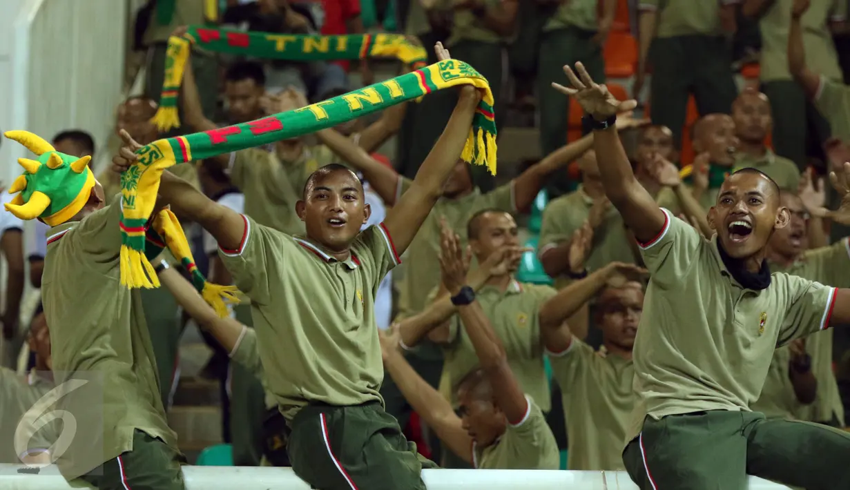Salah satu suporter PS TNI membentangkan syal dan bersorak saat menyaksikan laga timnya melawan Persib di lanjutan Liga 1 di Stadion Pakansari, Kab Bogor, Sabtu (22/4). Laga PS TNI melawan Persib berakhir imbang 2-2. (Liputan6.com/Helmi Fithriansyah)