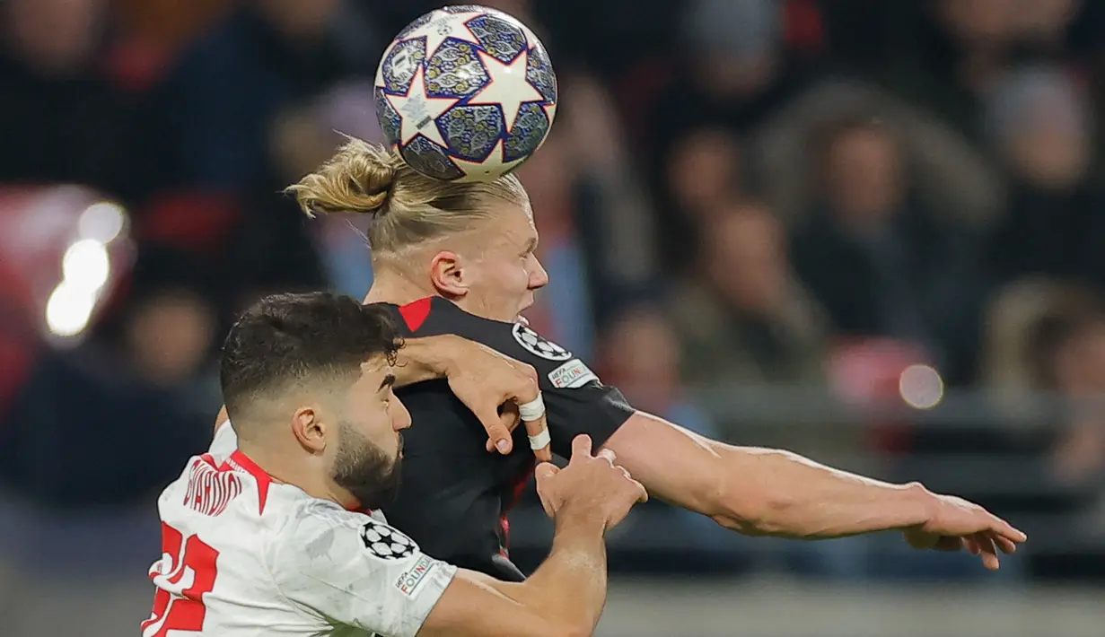 Pemain Manchester City, Erling Haaland (kanan) berebut bola di udara dengan bek RB Leipzig, Josko Gvardiol dalam pertandingan leg pertama babak 16 besar Liga Champions 2022/2023 antara RB Leipzig melawan Manchester City yang berlangsung di Red Bull Arena, Kamis (23/2/2023). (AFP/Odd Andersen)