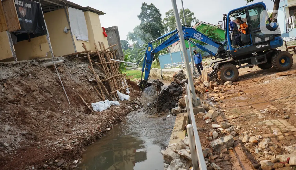 Alat berat mengeruk beton turap saluran air yang longsor di kawasan Jagakarsa, Jakarta, Kamis (17/9/2020). Selain karena hujan lebat, longsor diduga karena erosi tanah akibat pembuangan saluran air pencuci piring dan toilet dari warung makan di sekitar bantaran. (Liputan6.com/Immanuel Antonius)