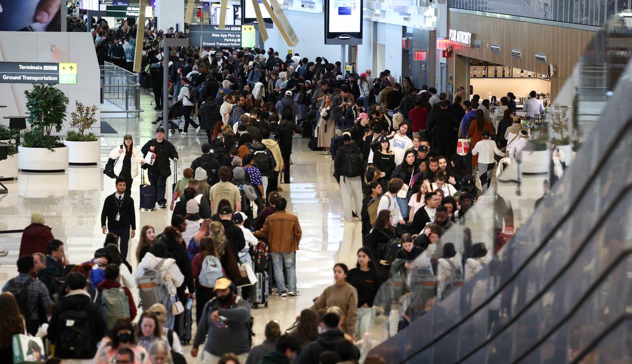 Kondisi ini berimbas pada antrean Panjang calon penumpang hingga penundaan penerbangan di berbagai wilayah. Tampak dalam foto, antrean para penumpang untuk melewati pemeriksaan keamanan di Bandara LaGuardia, New York pada Minggu 22 Maret 2026. (CHARLY TRIBALLEAU/AFP)