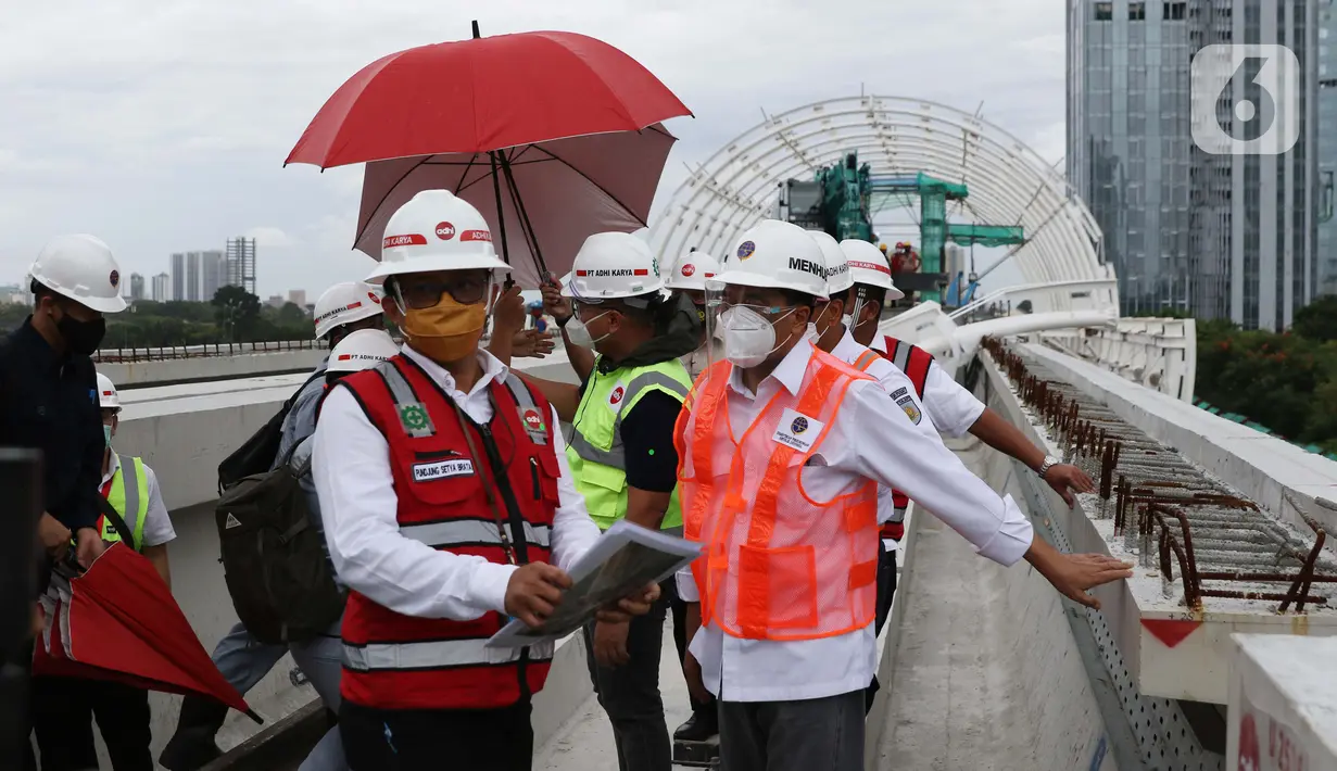 Menteri Perhubungan, Budi Karya Sumadi (kanan) saat meninjau Jembatan Bentang Panjang Dukuh Atas LRT Jabodebek, Jakarta, Minggu (29/11/2020). Saat ini progres pembangunan LRT Jabodebek sudah mencapai 79,52 persen dan ditarget akan beroperasi pada pertengahan 2022. (Liputan6/Helmi Fithriansyah)