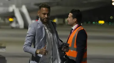 Penyerang Brasil Neymar memberi isyarat saat tiba dengan rekan setimnya menjelang Piala Dunia mendatang di bandara Internasional Hamad di Doha, Qatar, Sabtu (19/11/2022). Penerbangan Amerika Selatan dari Turin di Italia tempat timnas Brasil bermarkas minggu ini mendarat sekitar pukul 23:00 waktu setempat (21:00GMT). (AP Photo/Hassan Ammar)