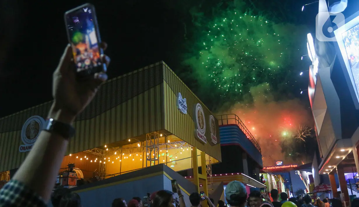 Pengunjung mengabadikan pesta kembang api saat pembukaan Jakarta Fair 2022 atau Pekan Raya Jakarta 2022 di Jakarta International Expo (JIExpo), Kemayoran, Jakarta, Kamis (9/6/2022). Jakarta Fair 2022 telah resmi dibuka dan akan berlangsung hingga 17 Juli 2022. (Liputan6.com/Herman Zakharia)